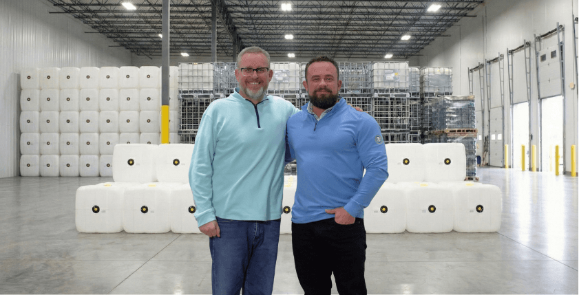 Owners Mike and David Harding standing in an MPH United warehouse full of IBC bottles